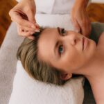 a person applying acupuncture needle on client s forehead